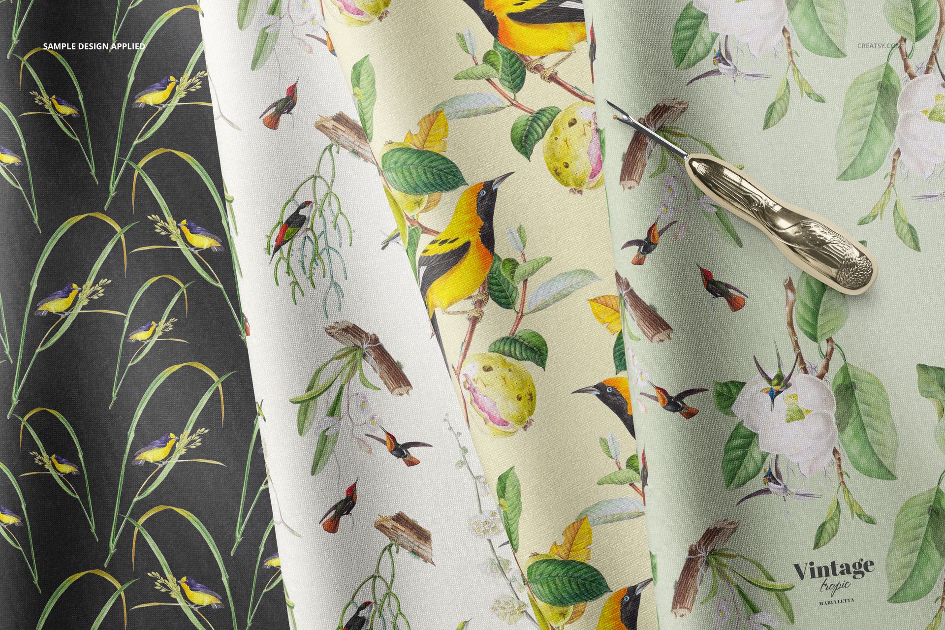 Folded fabric mockup showing four fabric pieces with botanical and bird patterns, viewed from above.