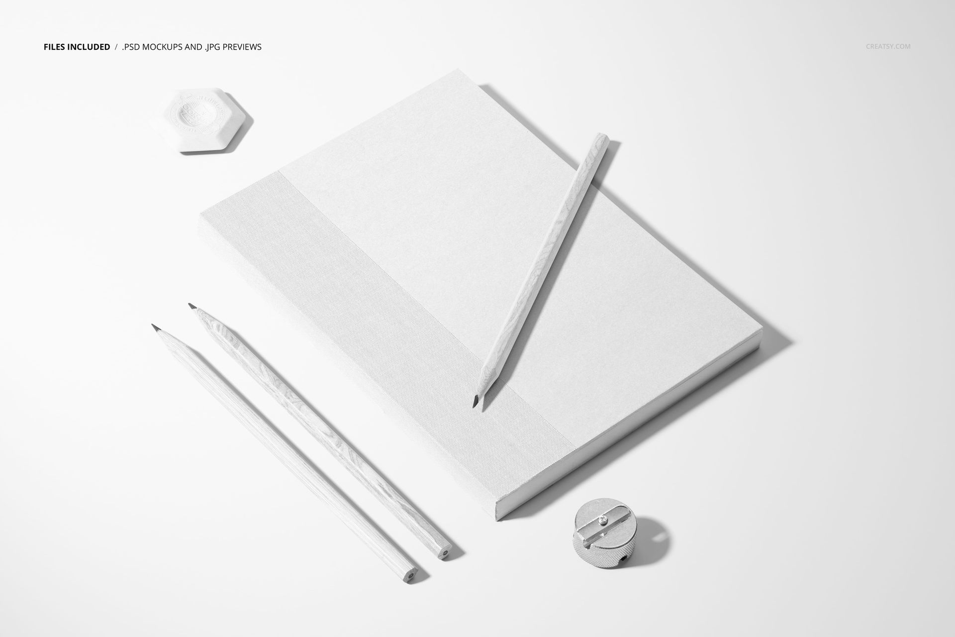 Stationery mockup showing a closed planner, three pencils, eraser, and sharpener arranged on a light background.