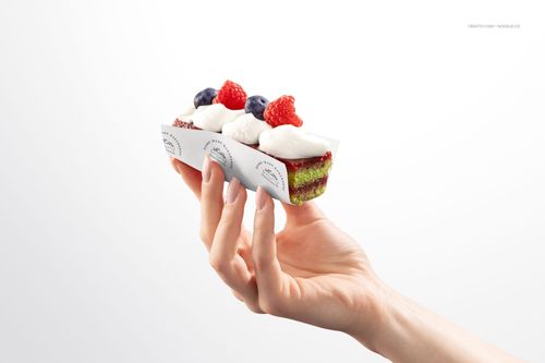 Rectangular pastry with cream and berries held in printed wrapping paper, isolated on a white background, PSD mockup.