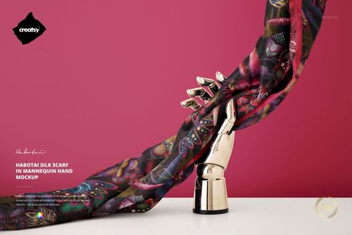 PSD mockup showing a patterned habotai silk scarf wrapped around a chrome mannequin hand, set before a bright pink wall.