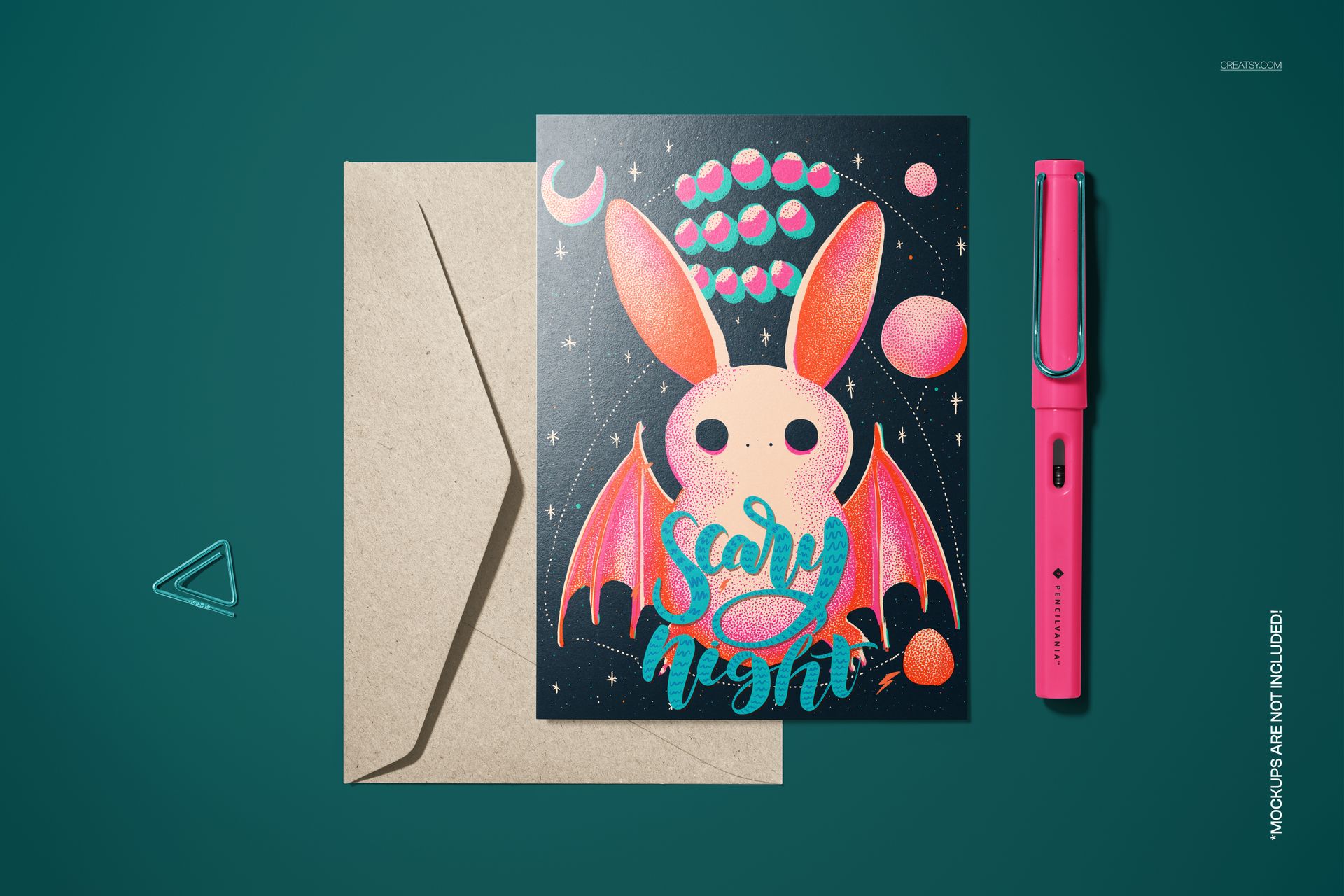 PSD mockup of a folded card with vintage bat artwork, displayed with envelope and pen on a teal background.