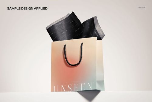 PSD mockup showing a gradient shopping bag with matching tissue paper, presented in a studio setting with subtle shadows.