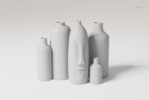 Front view of five sculptural minimalist vases in matte white, including one with a stylized face design, arranged on a plain surface.
