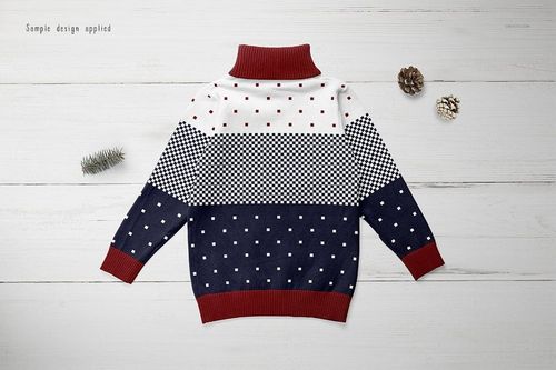 Kids turtleneck sweater mockup displayed flat on a white wooden surface, featuring geometric and dotted patterns.