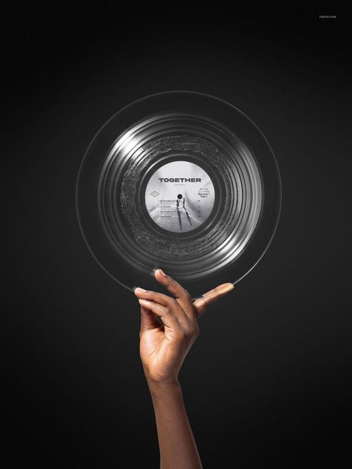 Hand holding a clear vinyl record with a visible center label against a dark background, music mockup scene.
