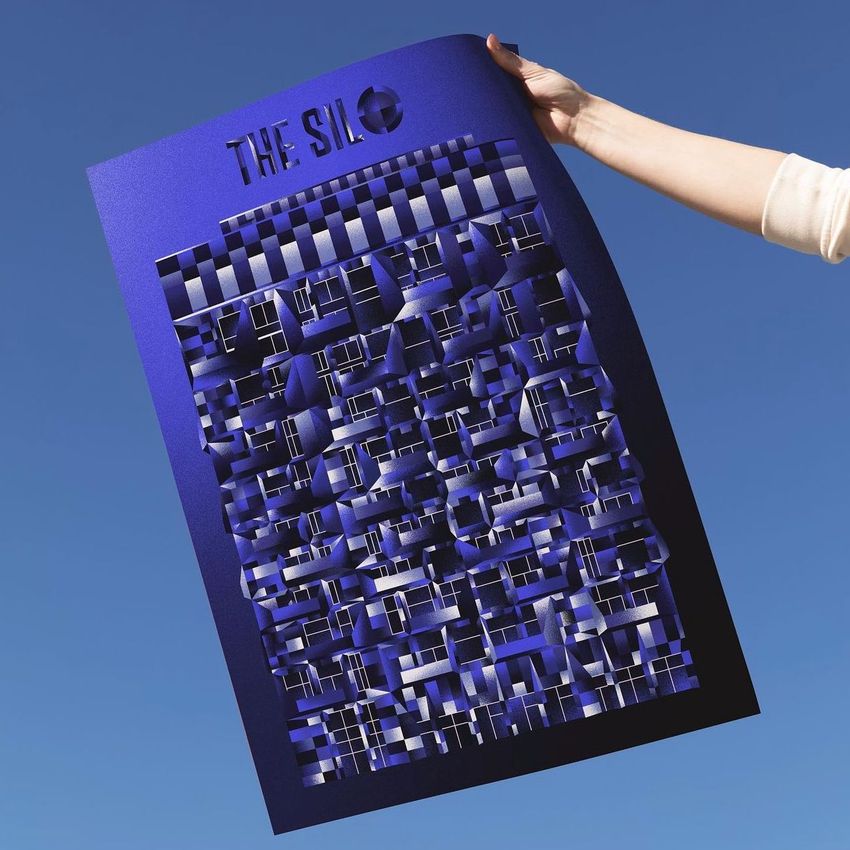 Hand holding a blue poster mockup with geometric abstract design and bold text at the top, set against a clear blue sky.