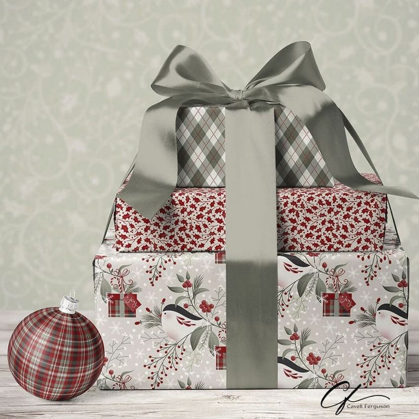 Christmas gifts mockup featuring three stacked presents wrapped in festive patterned paper with a large silver ribbon bow.
