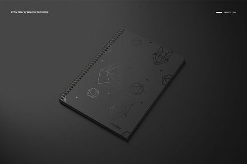 Black A4 notebook mockup with square holes and wire binding, geometric shapes on the cover, placed on dark surface.