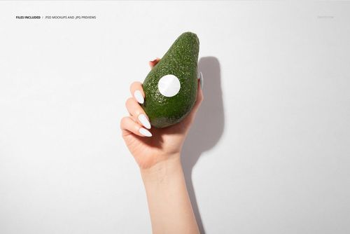 Avocado fruit with a blank round sticker held by a hand, displayed in a packaging mockup scene with a simple background.