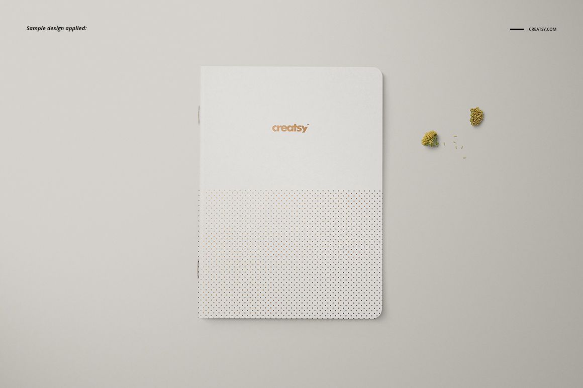 Front view of a classic A5 notebook mockup featuring a minimal white cover and subtle dotted pattern at the bottom.