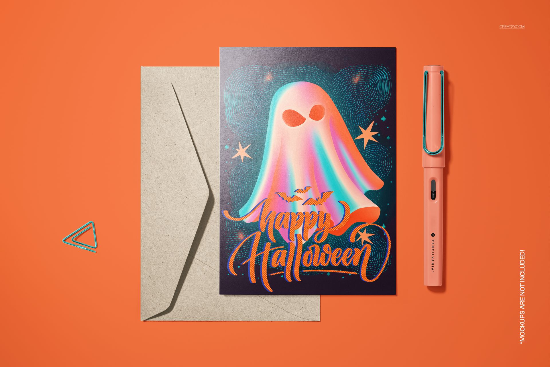 Halloween card mockup featuring a vibrant ghost design, bats, and cosmic elements, shown with an envelope and pen on orange background.
