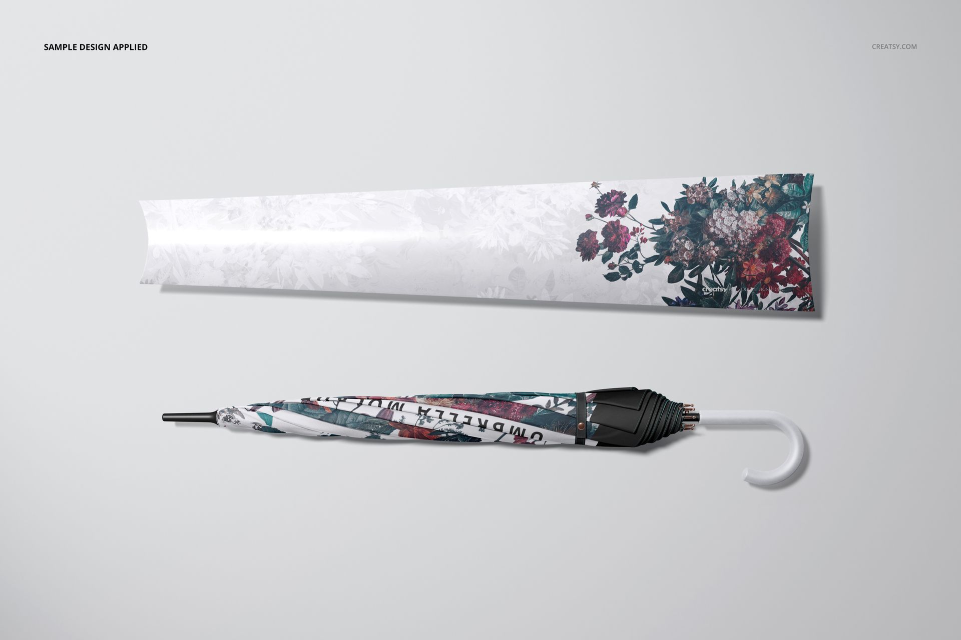 Closed umbrella and matching packaging sleeve with floral pattern, displayed on a light surface in a front view mockup.