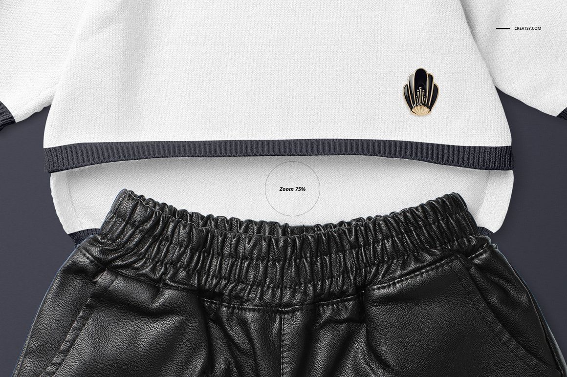 Front view of a baby sweater mockup in white with dark trim, paired with black faux leather pants on a plain background.