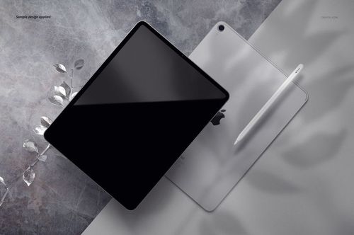 iPad Pro PSD mockup featuring a tablet with a black screen, another showing the rear, and a stylus on a marbled background.
