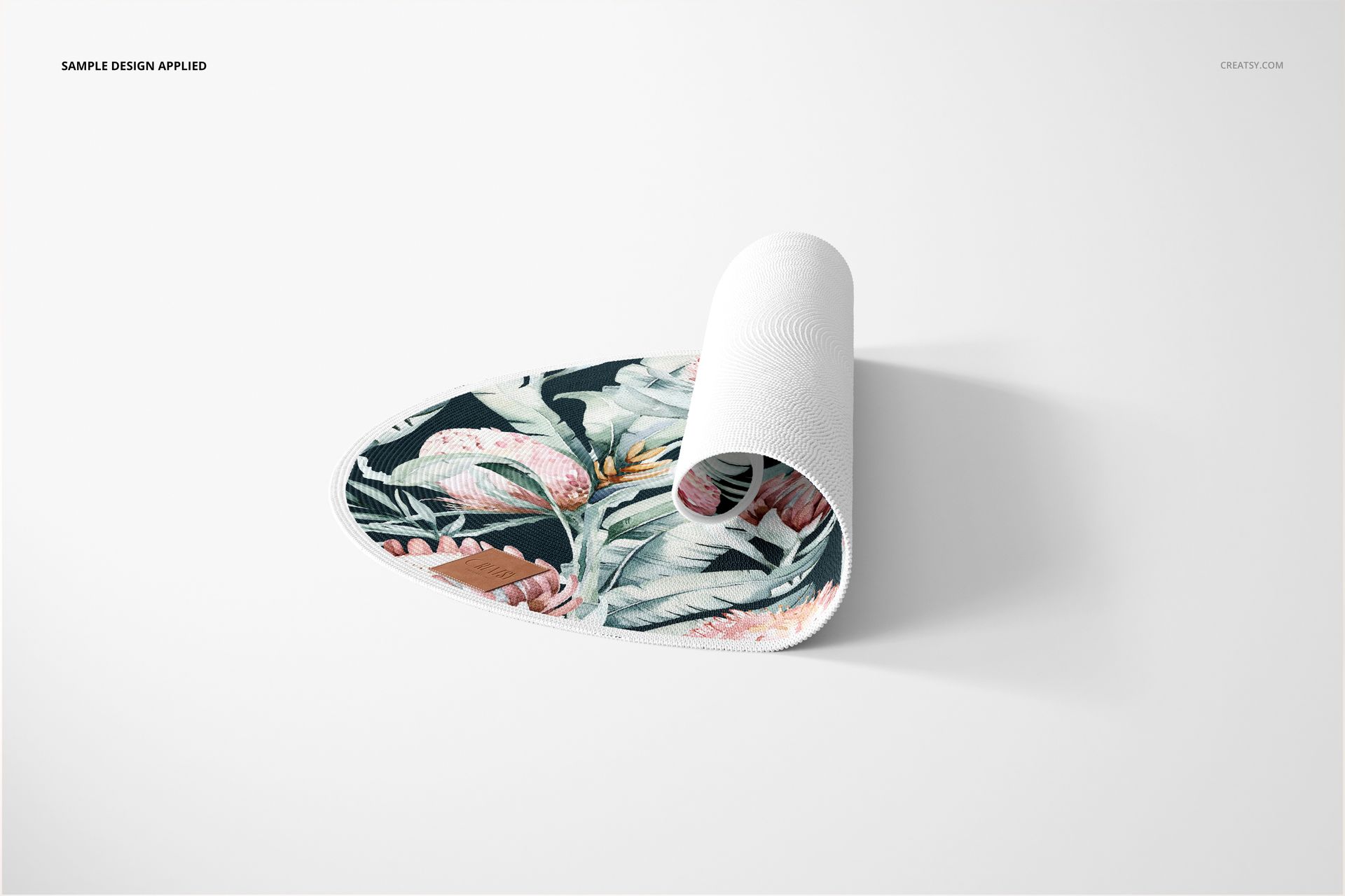 Round knitted rug mockup featuring a botanical design, shown partially rolled with visible textured edges.