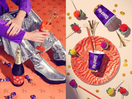 Party scene with a champagne bottle, orange glass, and silver boots on the left, colorful tableware and cups on the right.