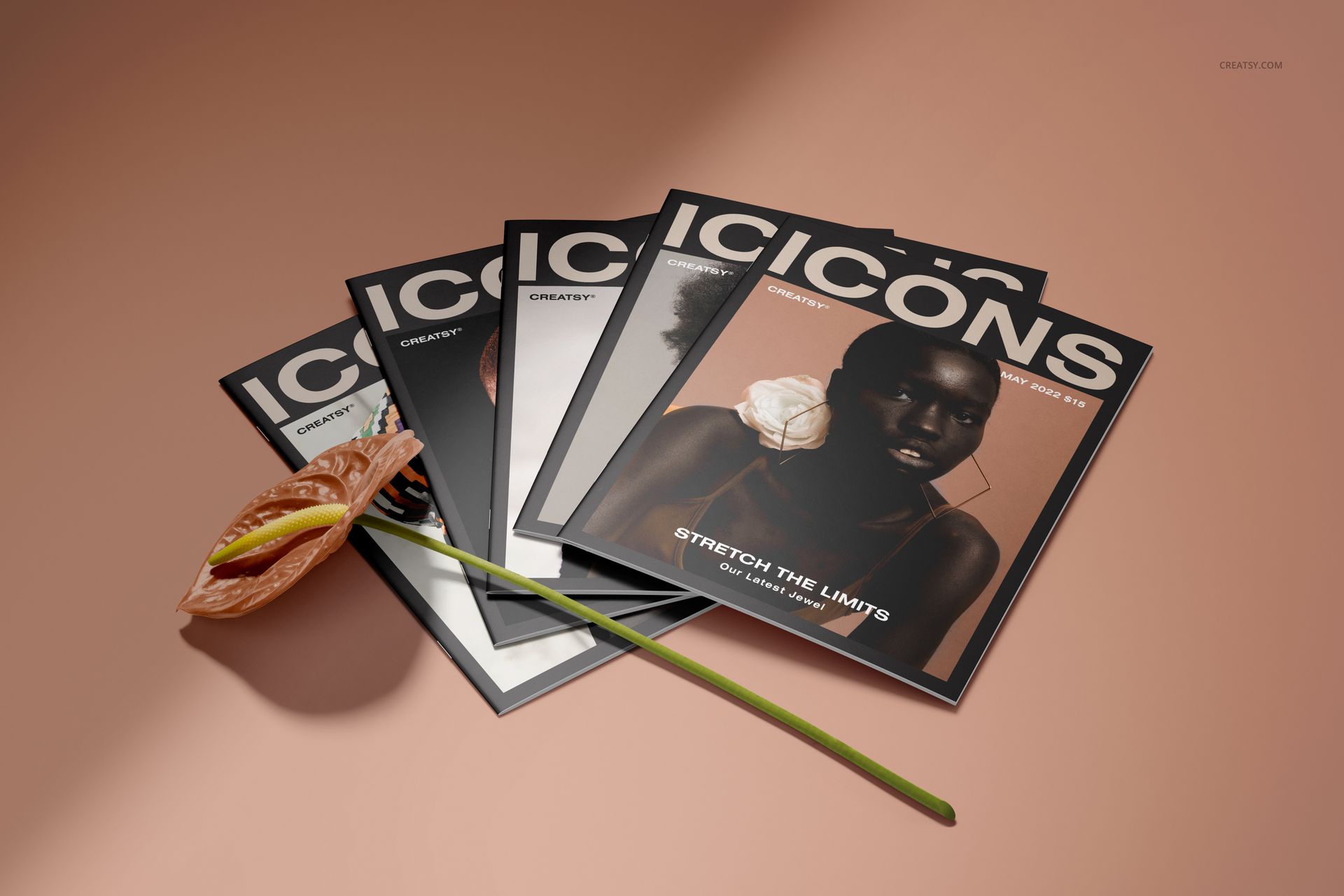 Fan arrangement of 8.5x11 magazine PSD mockups featuring dark covers and a single pink flower on a neutral surface.