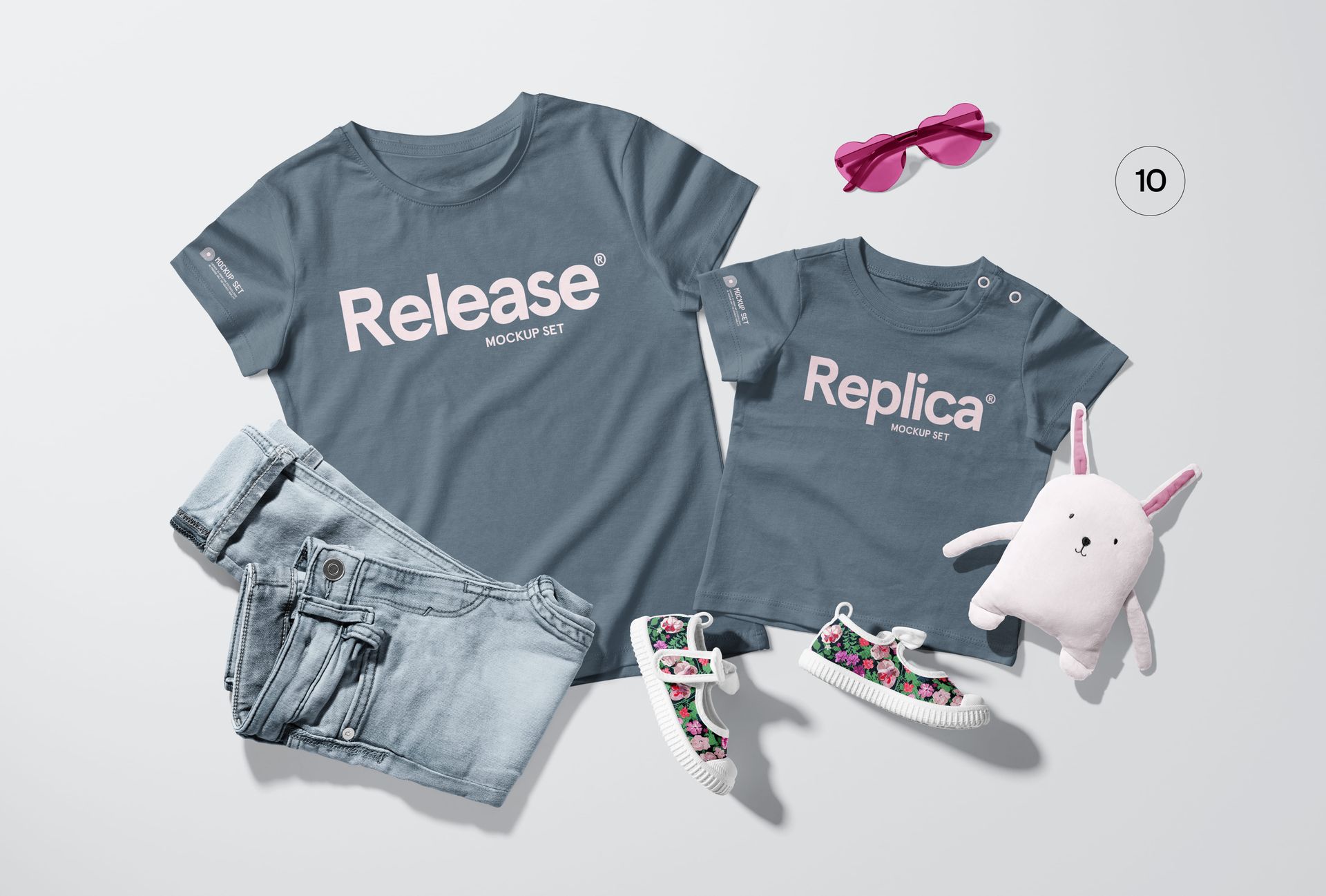 Flat lay of a family apparel PSD mockup featuring matching blue t-shirts, denim jeans, floral shoes, and a plush bunny.
