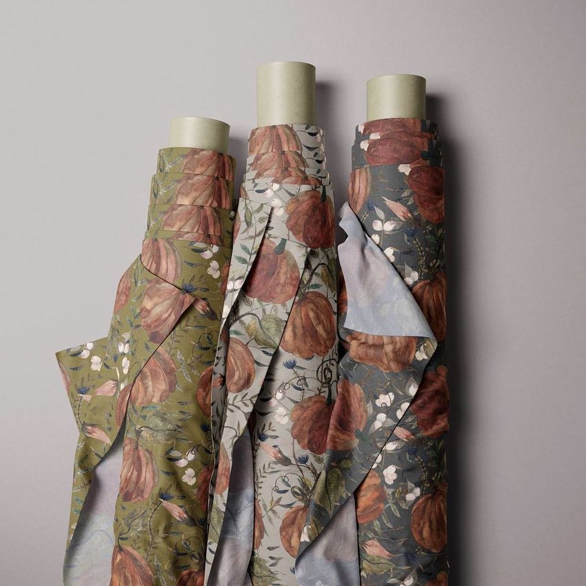 Three fabric rolls mockup featuring autumn-themed pumpkin patterns in earthy green, beige, and blue tones on a plain background.