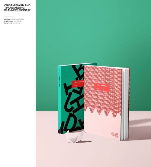 Mockup of two hardcover planners standing side by side, featuring modern graphic covers and a small paper origami swan.