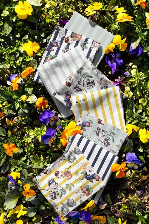 Floral and striped fabric pieces laid out on vibrant pansy flowers, showing detailed patterns in a PSD mockup scene.