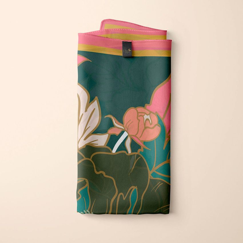 Silk scarf mockup featuring a folded scarf with a floral pattern in green, pink, and cream tones, displayed on a beige background.
