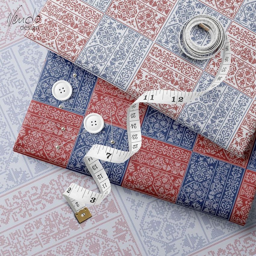 Folded fabrics mockup featuring red and blue patterned textiles arranged with a measuring tape, buttons, and pins on a light surface.