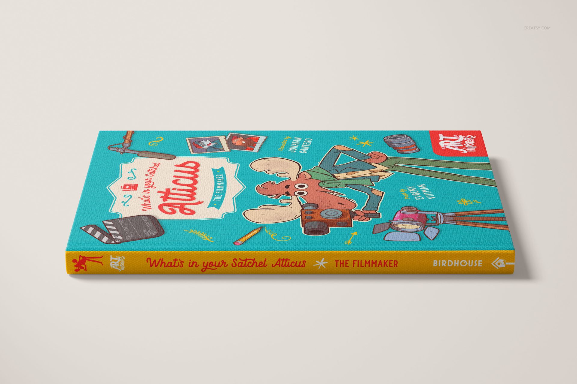 PSD mockup of a hardcover book with bright blue cover and playful illustrations, displayed from a side perspective.