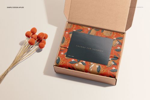 Stationery mockup featuring a card and envelope with a colorful floral design inside a kraft box, top angle.