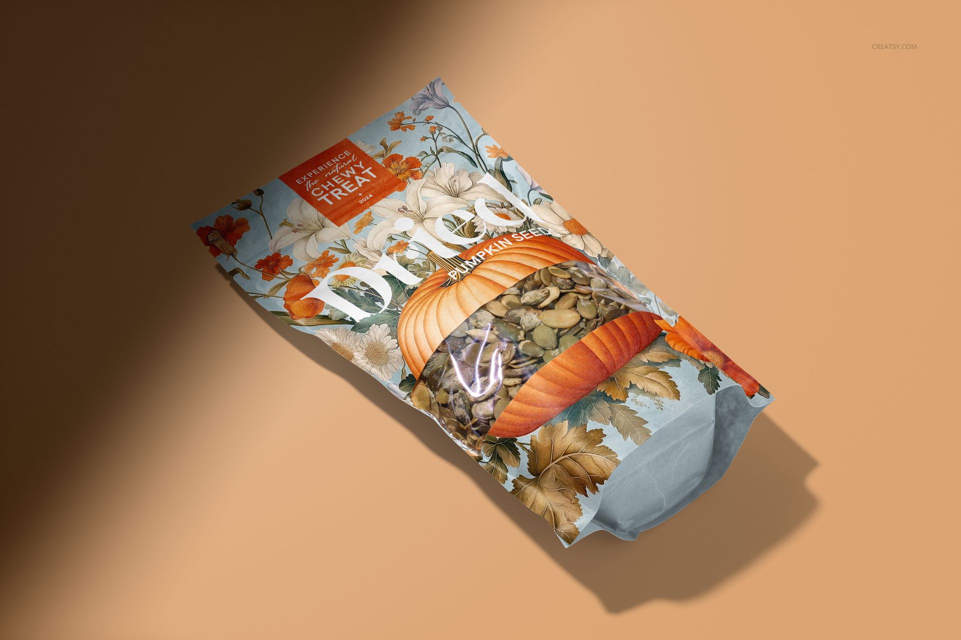 Paper pouch mockup featuring pumpkin seeds, decorated with orange pumpkins and fall leaves, angled on a neutral background.