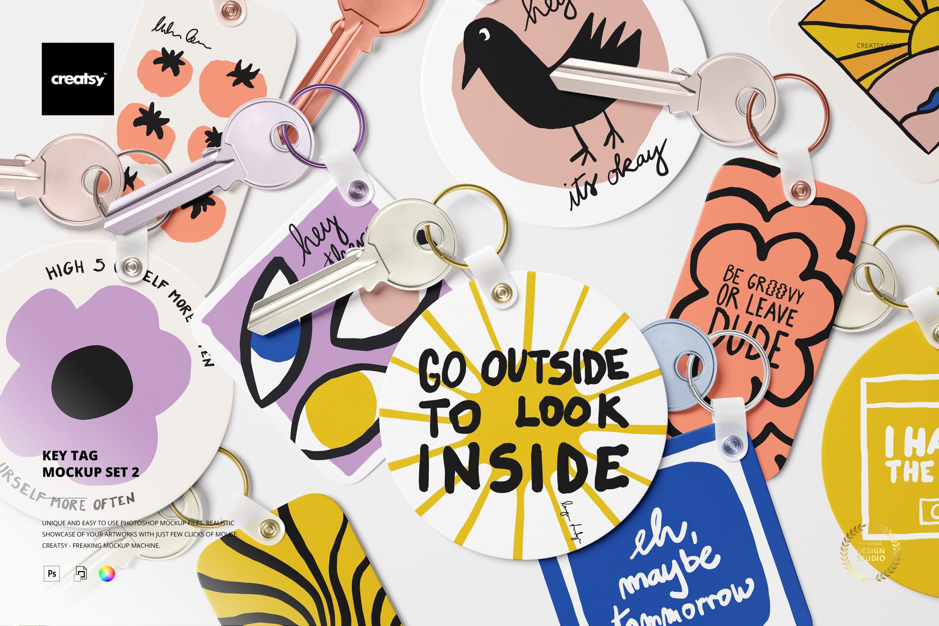 PSD mockup featuring several key tags with playful graphics and handwritten text, arranged flat with keys on a clean surface.