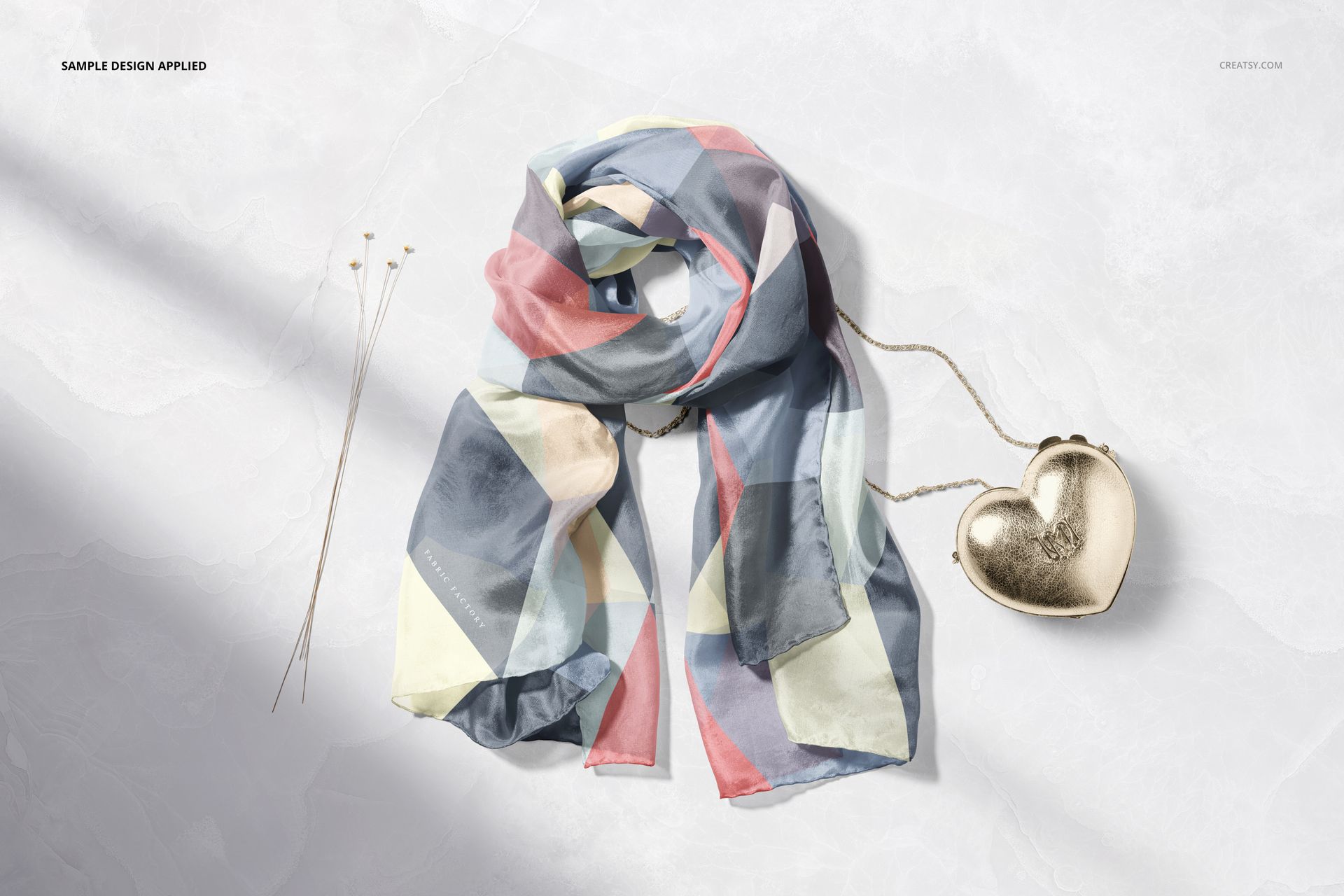 Bag and chiffon silk scarf mockup featuring a soft, multicolored scarf and a gold heart-shaped accessory on a marble background.