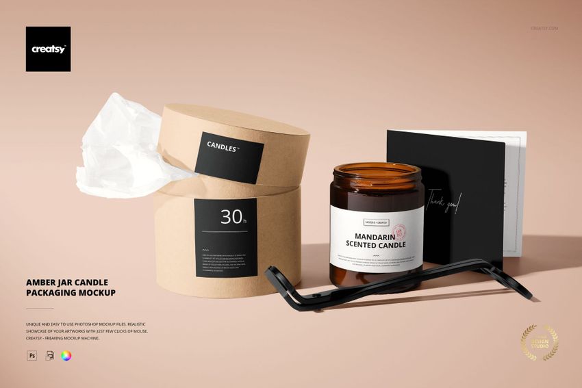 PSD mockup featuring a mandarin scented amber jar candle, kraft paper packaging, and black accessories on a beige background.