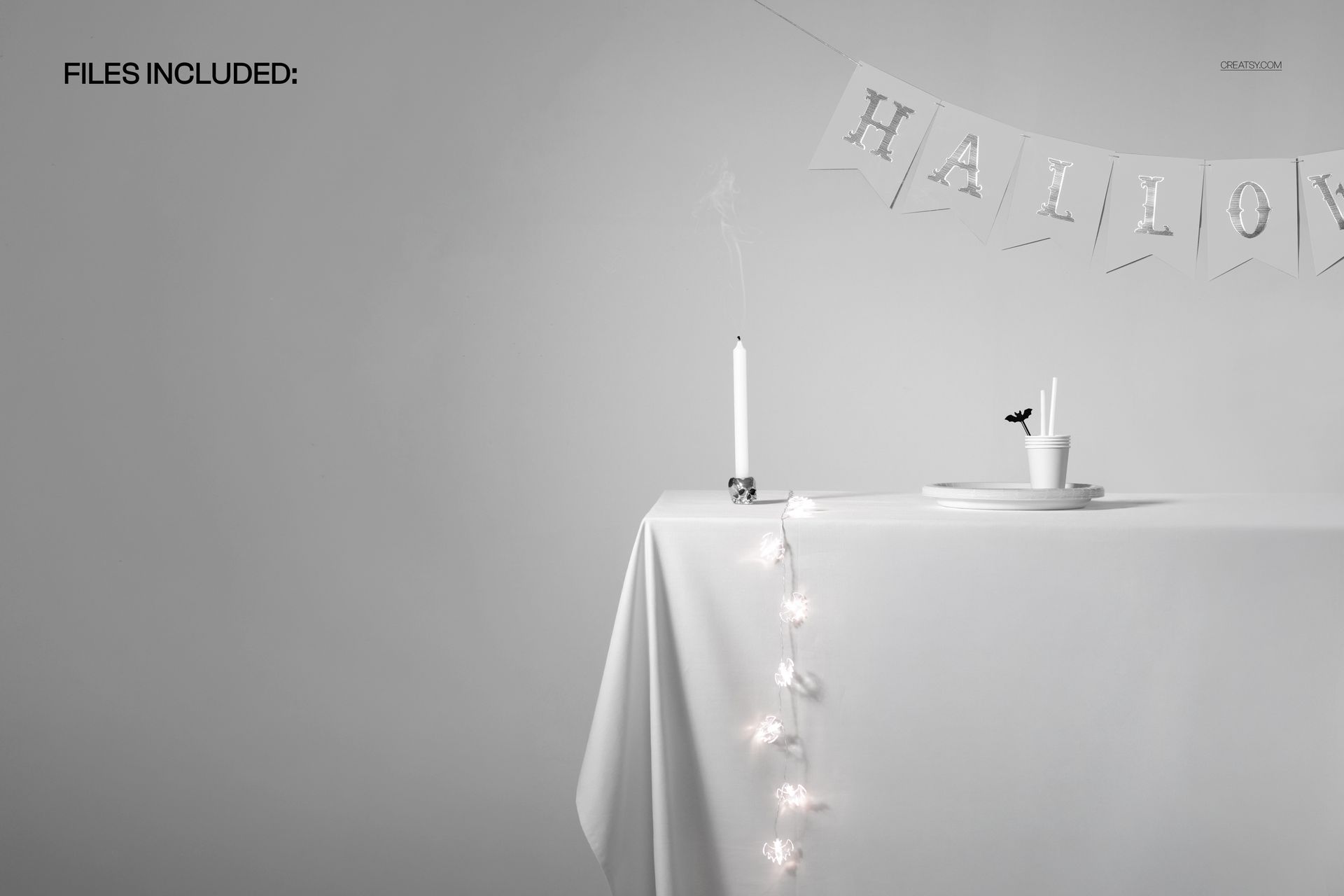 Front view of a white tablecloth mockup with Halloween banner, candle, cup, and string lights in a minimal scene.
