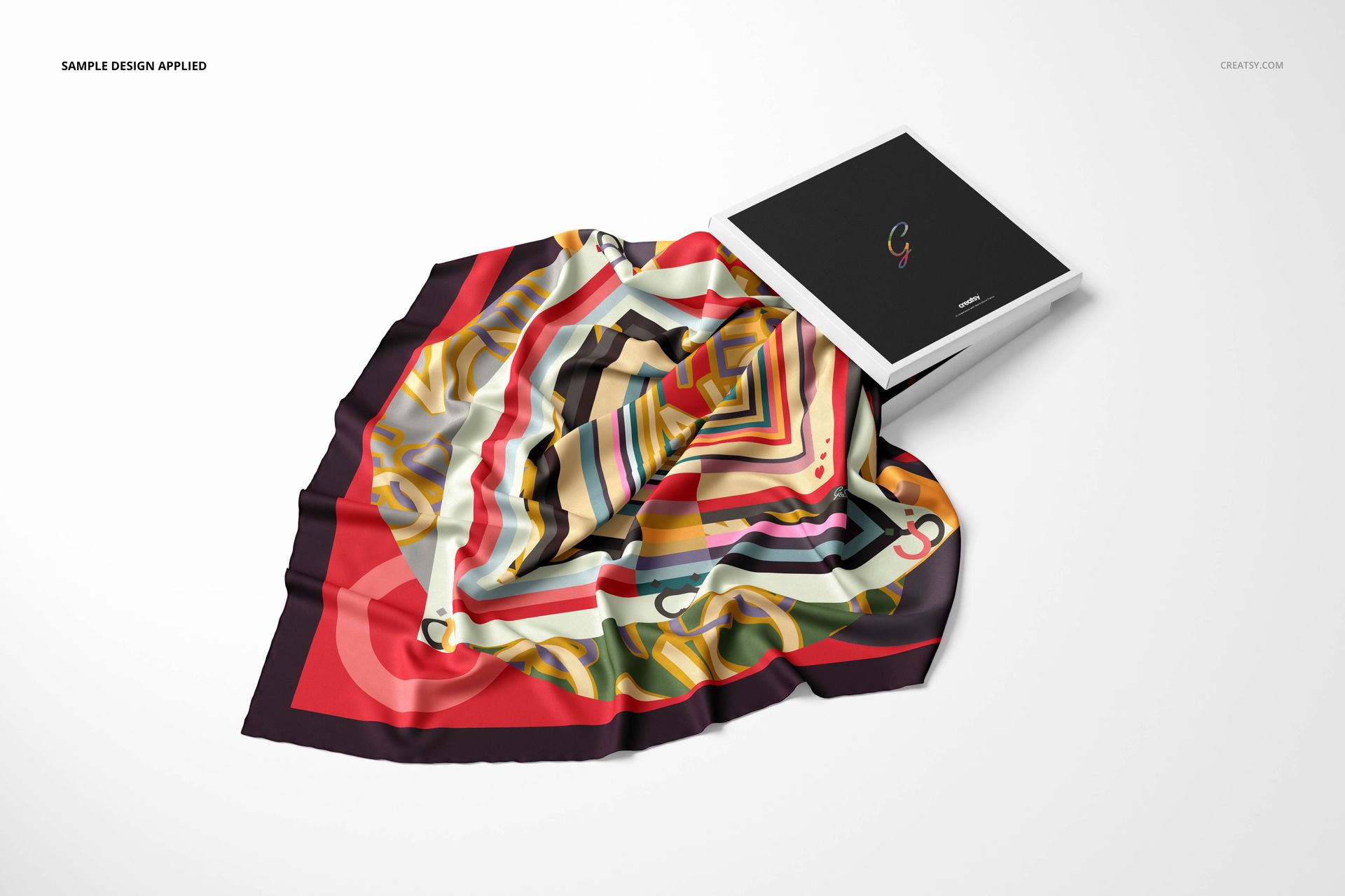 Colorful twill silk scarf mockup featuring bold geometric shapes and wavy lines, shown beside a closed black box.