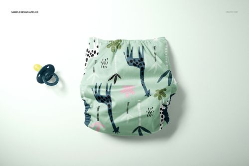 Reusable baby cloth diaper with a playful giraffe and leaf pattern on a light green background, shown in a front view mockup.
