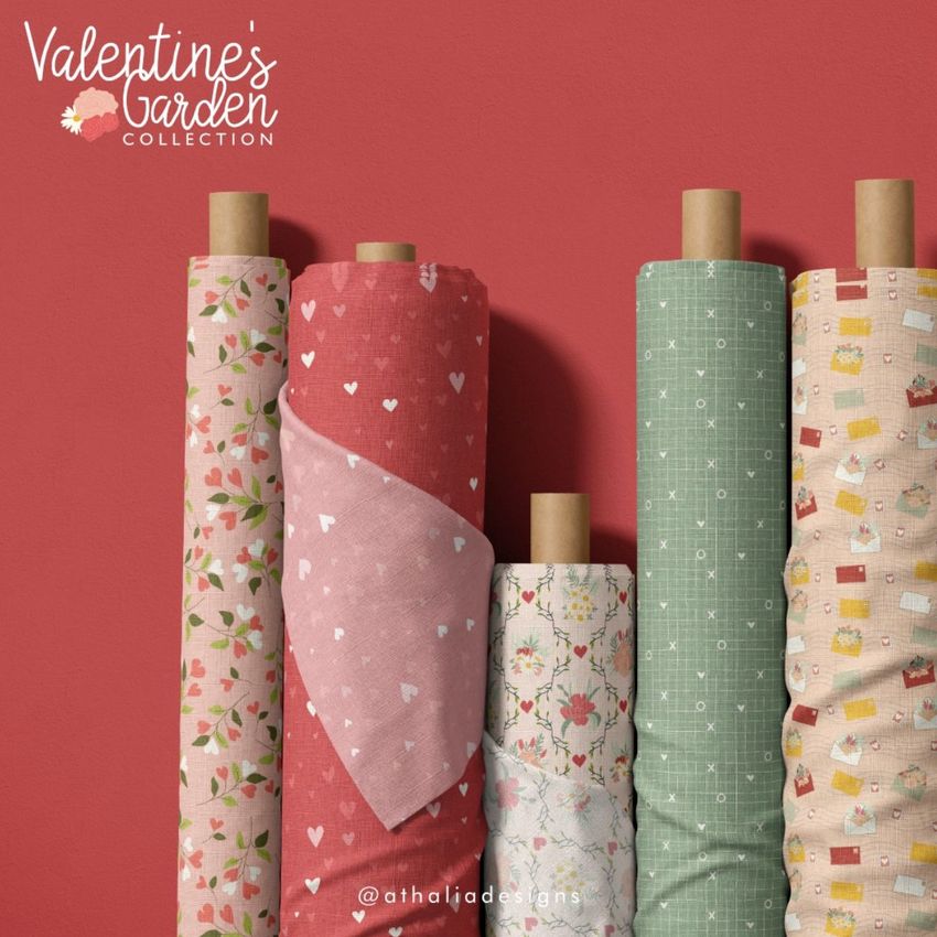 Fabric rolls mockup featuring five upright rolls with various patterns, including hearts, florals, and geometric shapes on pastel backgrounds.