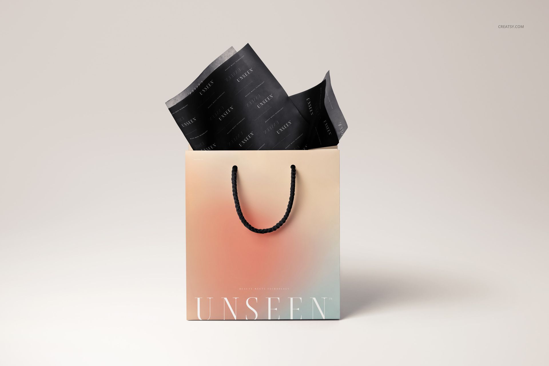 PSD mockup showing a pastel-colored gift bag with black rope handles and decorative black tissue paper inside.