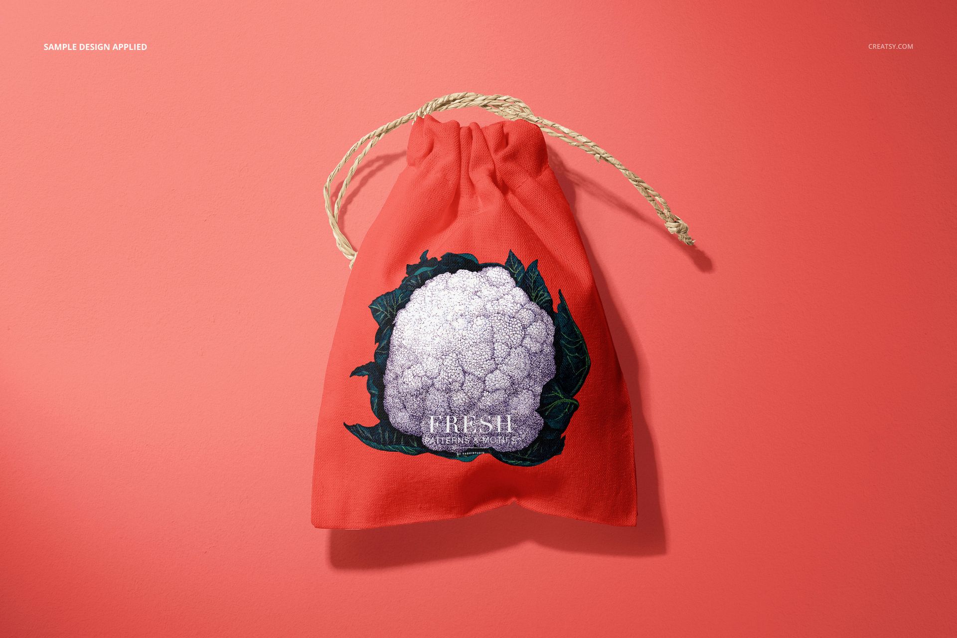 Front view of a linen drawstring pouch mockup in coral color, featuring a cauliflower illustration and rope drawstrings.