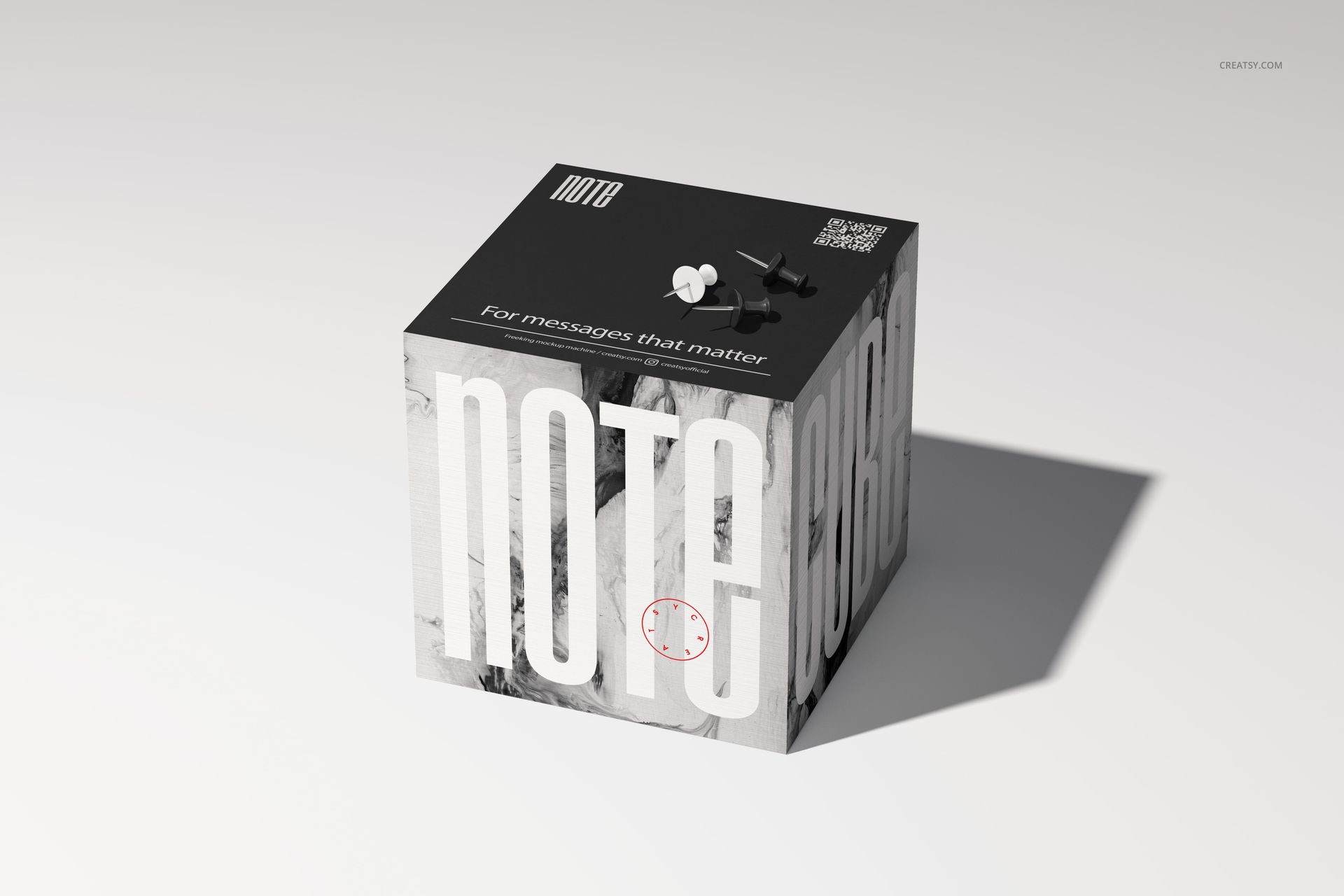 Mockup of a square note cube with large white lettering, black top surface, and subtle shadow on a light background.