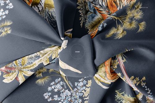 Top view of a fabric gift wrap mockup featuring intricate floral and tiger designs on a gray surface, knotted at center.