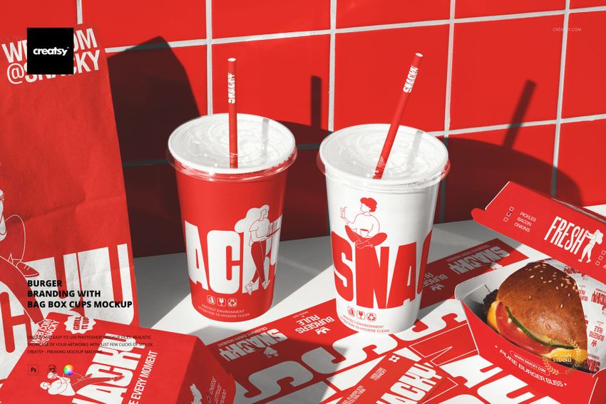 Front view of burger packaging mockup featuring red and white branded paper bags, cups, boxes, and a burger on a tiled surface.