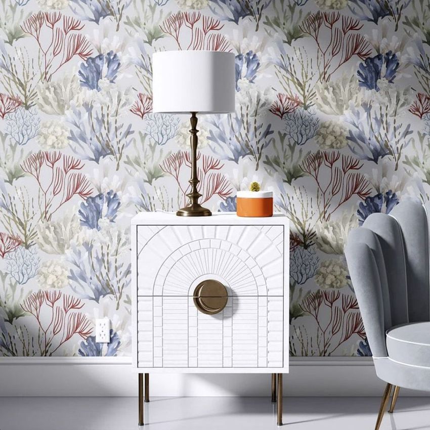 Drum lamp shade mockup displayed on a bronze table lamp, set on a white cabinet against a floral patterned wallpaper.