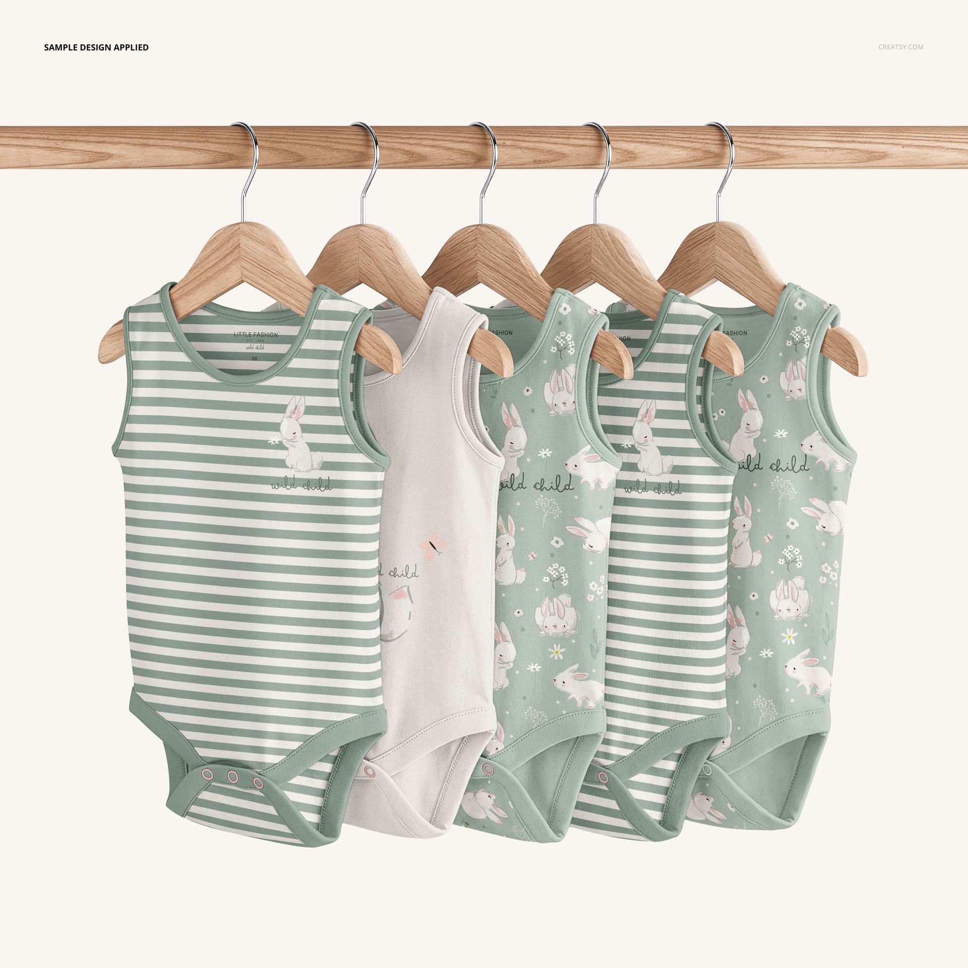 Five sleeveless baby bodysuit mockups hanging on a wooden rack, showing striped, solid, and bunny-themed prints.