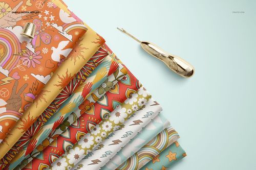 PSD mockup of patterned folded fabrics in orange, yellow, and pastel shades, arranged diagonally on a pale background.