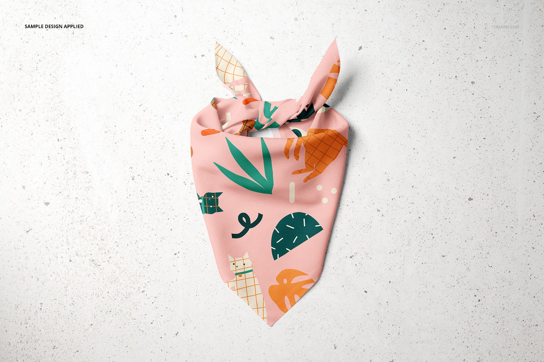 Front view of a pet bandana mockup with colorful abstract patterns on a pink fabric, lying flat on a textured background.