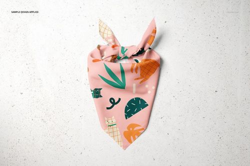 Front view of a pet bandana mockup with colorful abstract patterns on a pink fabric, lying flat on a textured background.