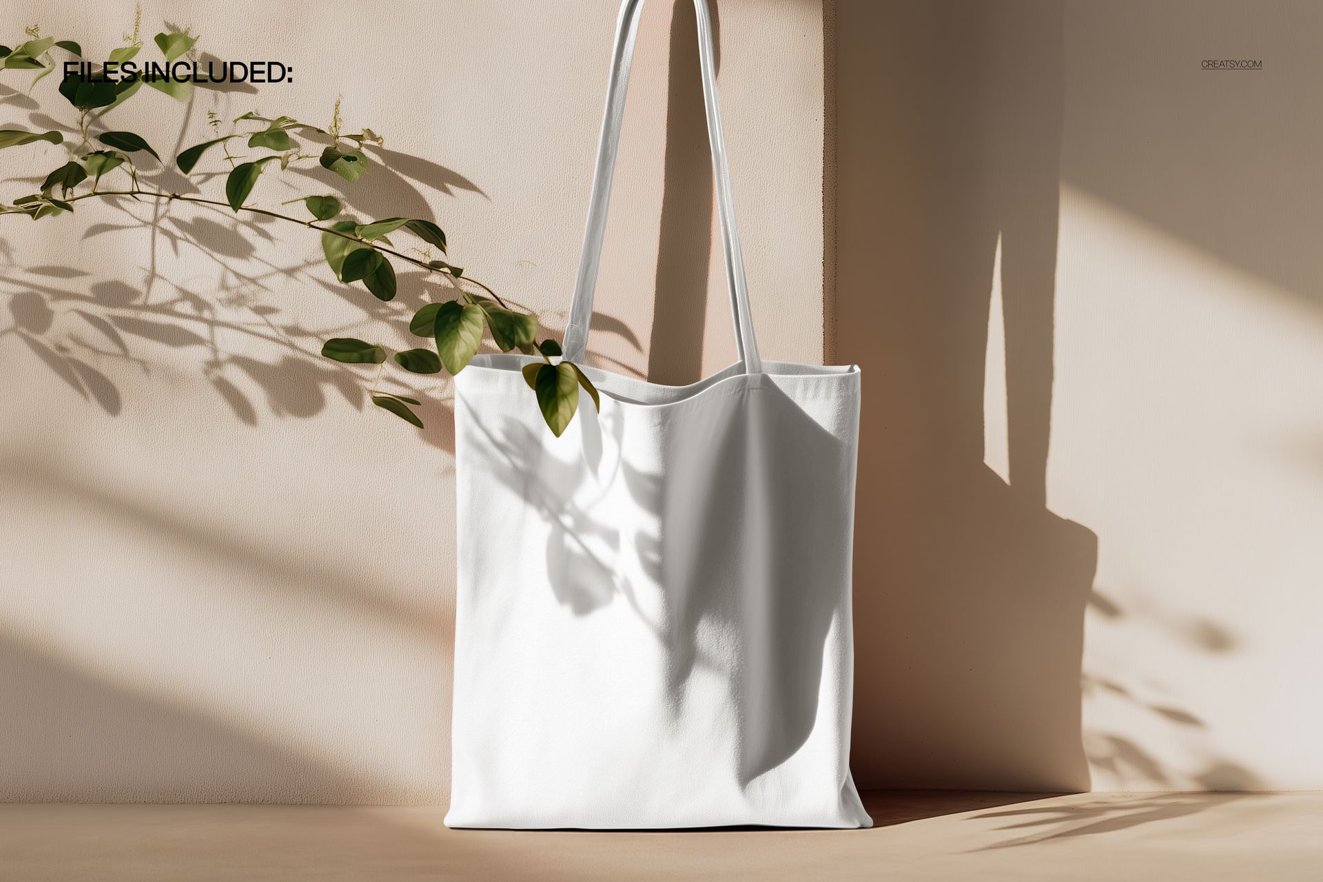 PSD mockup of a simple canvas tote bag in a minimal setting, featuring natural light and plant shadow details.