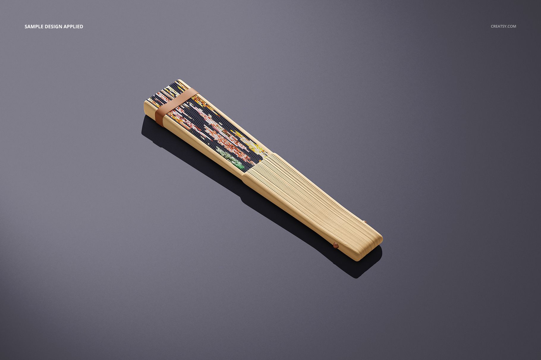 Fabric hand fan mockup featuring wooden slats and a decorative patterned section, displayed on a gray background.