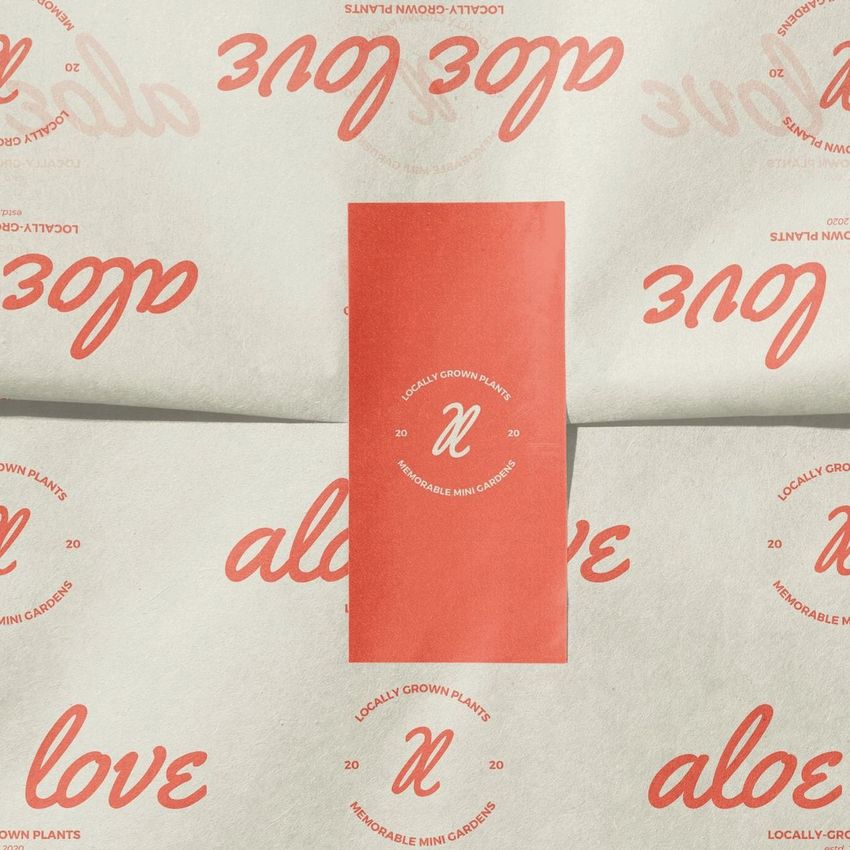 Sticker mockup featuring a rectangular red sticker on cream-colored tissue paper with repeating red text and circular logo.